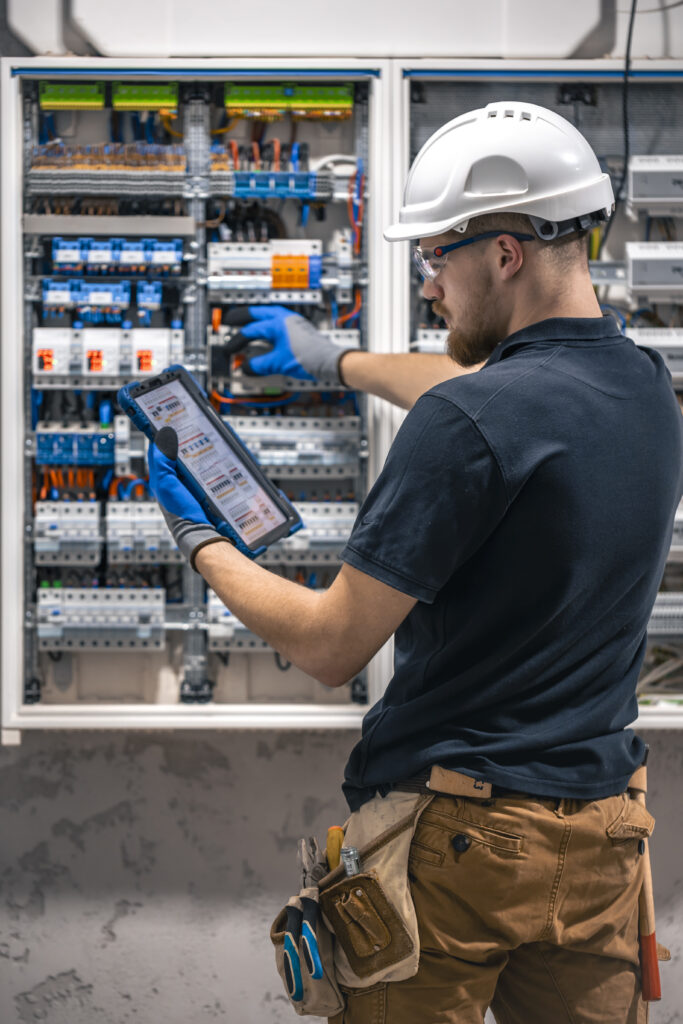 Electrical technician working in a switchboard with fuses, uses a tablet. Electrical technician looking focused while working in a switchboard with fuses. SSUCv3H4sIAAAAAAAACpySwW6DMAyG75P2DijnIgGBju5Vqh1MSMFqmlRJ6DRVffc5CaDsOnHBn+3f/jHP97eiYAM4FOyzeIaIYlRqcd6CR6MJV4eVW6lHaXPysPxY5QAwj+SI3lgElcMBvJg13CRBvSgV8CsmmfPgFydd2GVFArycSCPBXSItfE5xsSVikjooxdghY24ZIttQEv9XZ3r52g1PUoufuHBmxEolIRk5p1J2/fbS3nJrsIxoMlcPI0CFAp4pAd7Bwp++u0WBesqI8XO8y6YkzKK9DVvtZpgy5g6DCl/9QmPkxmdwjsrHjWezBf0F5pbN0cZHT6sqG+k4Iaw5747NBz193fZN1ZzWgnTQGUknrrMJUSyuOOauMGxAJzi1XVdBCU3Ly7aq67Lvu65seNe3cOLHgV/oFq9fAAAA//8DAIlQOhS5AgAA